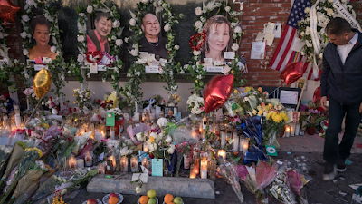 The gates outside the Star Ballroom Dance Studio have become surrounded by a makeshift memorial with flowers and portaits of the victims