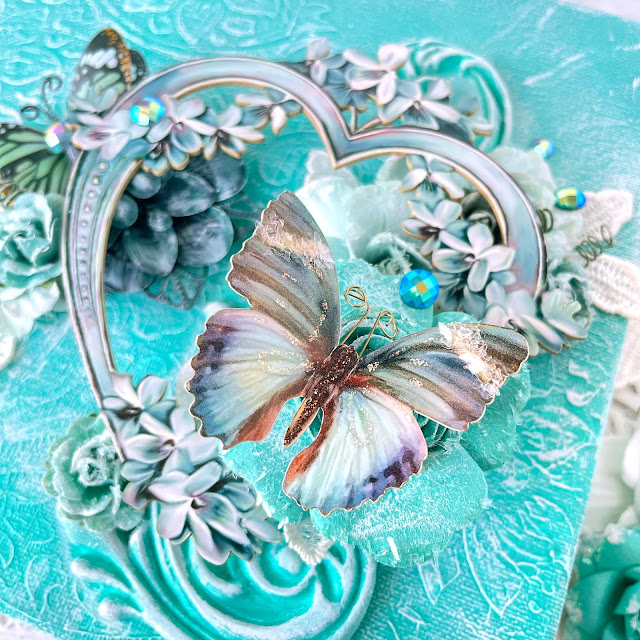 Mixed media canvas created with: Prima Marketing lace paper flowers, coffee break, Zella teal, magical love, finnabair jade impasto paint, grungy succulents, bindweed stencil; Reneabouquets patina lilac chipboard heart frame, into the mystic butterflies, gawdie girl glitter glass in ocean