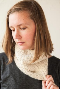 Image shows woman wearing knit cowl around her neck