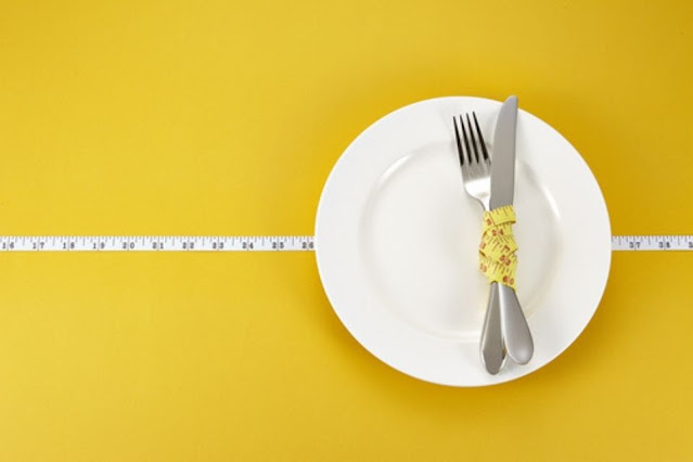 Fork and knife wrapped up in a measuring tape