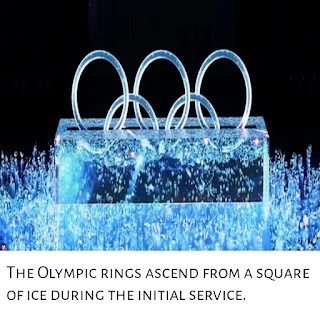 The Olympic rings ascend from a square of ice during the initial service.