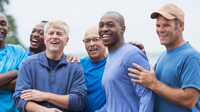 A group of men in blue shirts posing for a photo.