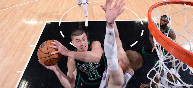 Payton Pritchard trying to make a contested layup against a Sacramento Kings player.