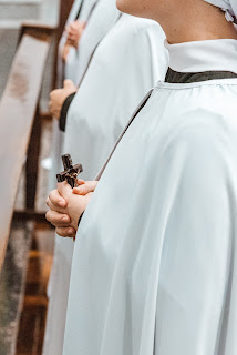 Monja sostenint amb tendresa un crucifix - Foto de Mateus Campos Felipe via Unsplash