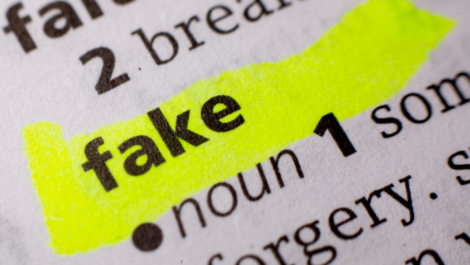 A stock image from Canva showing the word fake in a dictionary highlighted in a post talking about how to identify fake engagement on Instagram