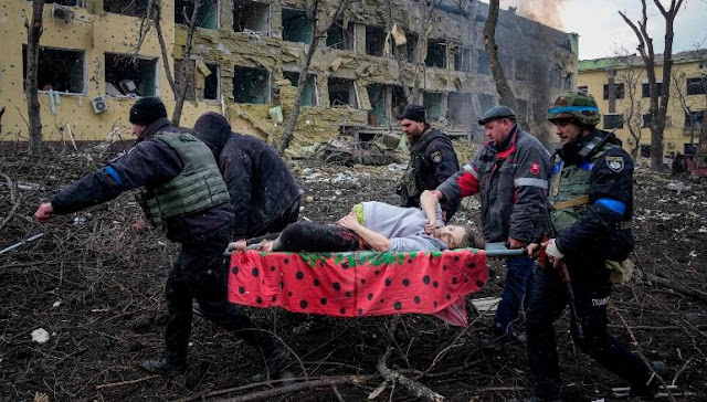 Ukrainian emergency employees and volunteers carry an injured pregnant woman from a maternity hospital that was damaged by shelling in Mariupol, Ukraine, Wednesday, March 9, 2022.