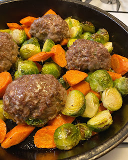 Photo of mini meatloaves and vegetables in a cast-iron skillet