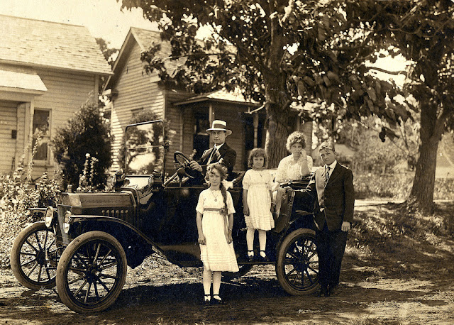 Gente posando con sus coches a principios del siglo XX