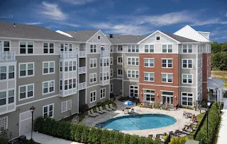 Exterior image of pool and apartment building at The Commons at SouthField Highlands in Weymouth