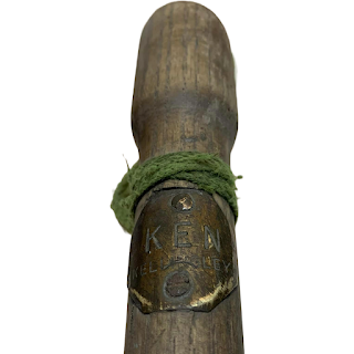 The top of the wooden deputy stick, with a metal badge attached engraved with 'Ken - Kellingley'