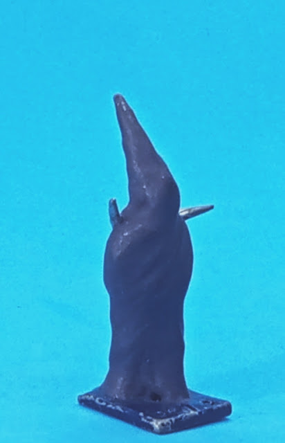 This is a vaguely humanoid shape with a twisted pointed head, rather like a hood or a candle flame.  It's painted purple.