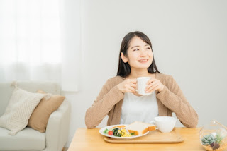 栄養バランスの良いご飯を食べる女性の写真