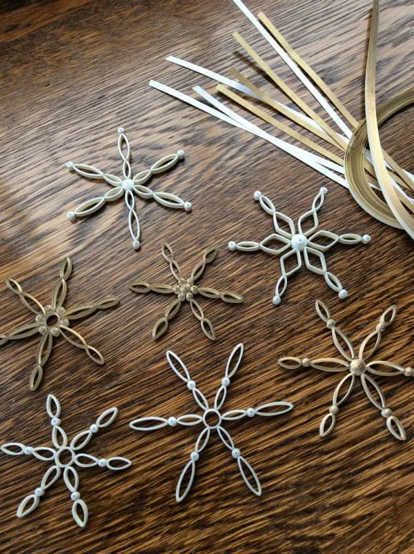 modern quilled snowflake tree ornaments shown with supplies