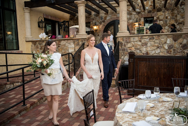 at last weddings coordinator walking couple into reception