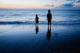 siluet anak-anak di jam biru muda di pantai