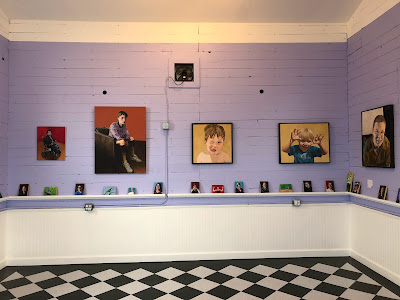 Art gallery wall with portrait paintings hanging