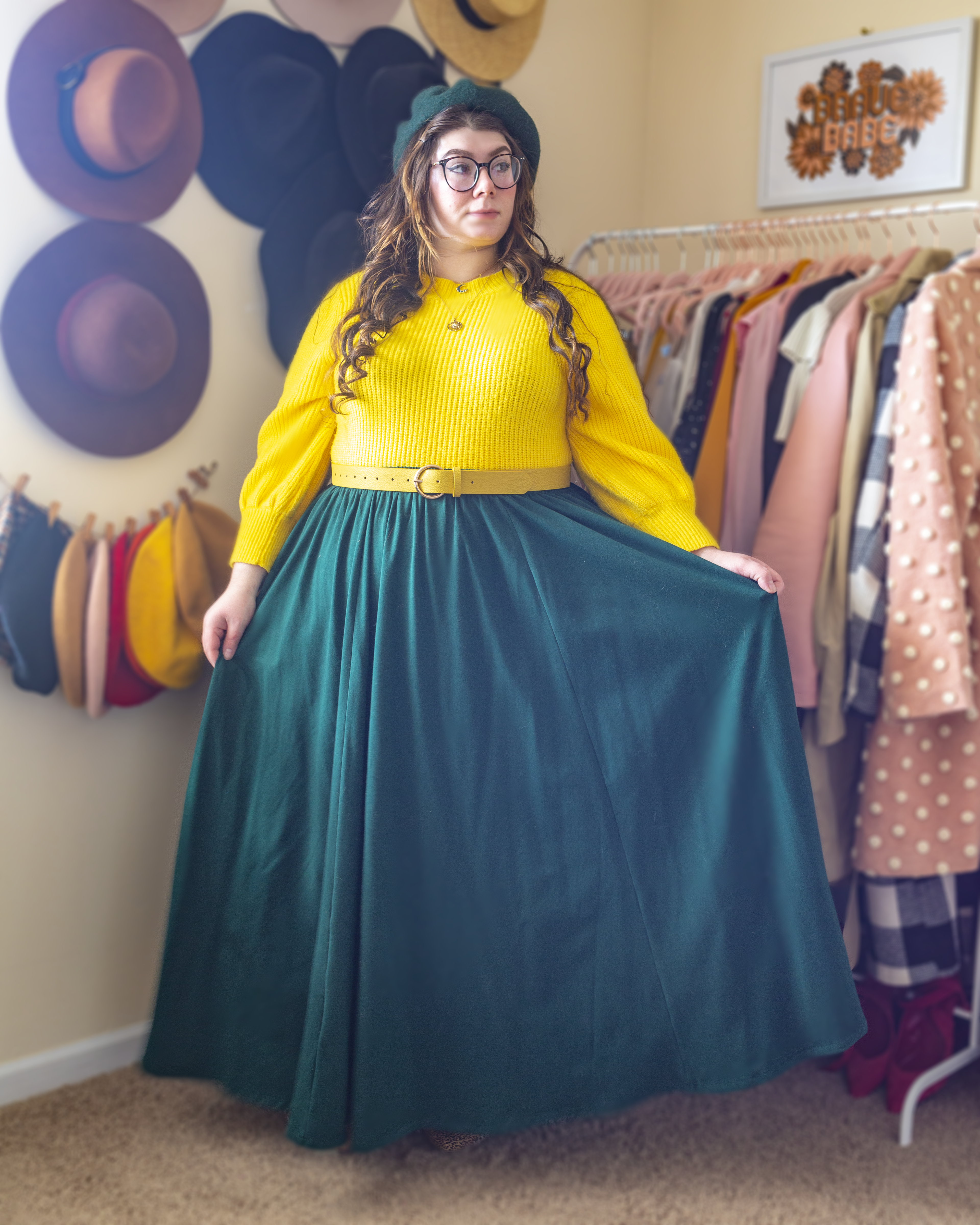 An outfit consisting of a banana yellow mock neck sweater with balloon sleeves tucked into a dark green floor length A-line skirt and beige and black animal print heeled clogs.