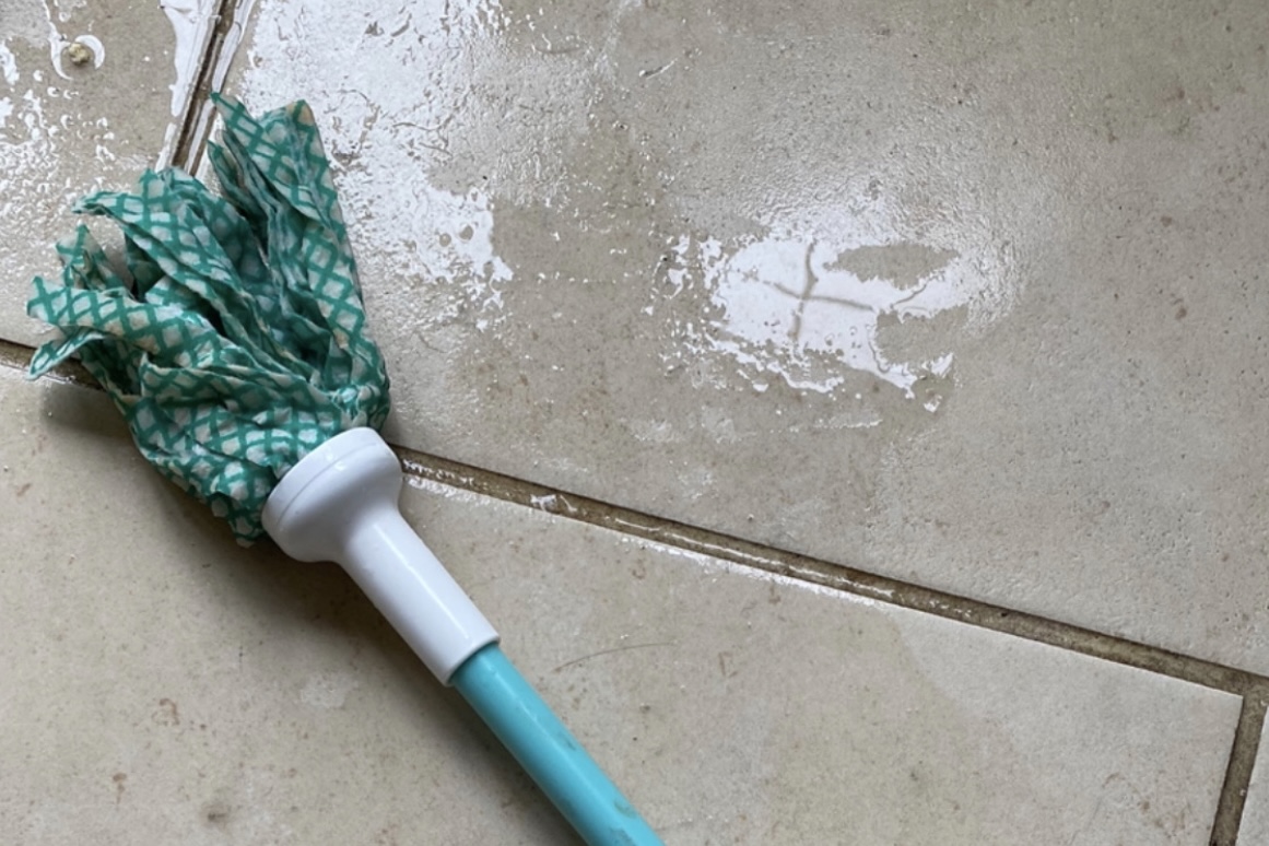 A mop cleaning a dirty floor that is in need of a deep clean which is perfect for spring cleaning