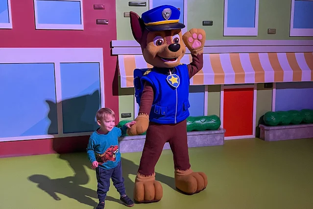 3 year old holding hands with Paw Patrol's chase in a meet and greet at Lakeside