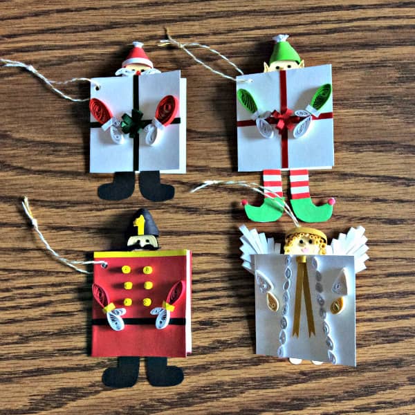 four quilled Christmas gift tags featuring angel, wooden soldier, Santa, and elf