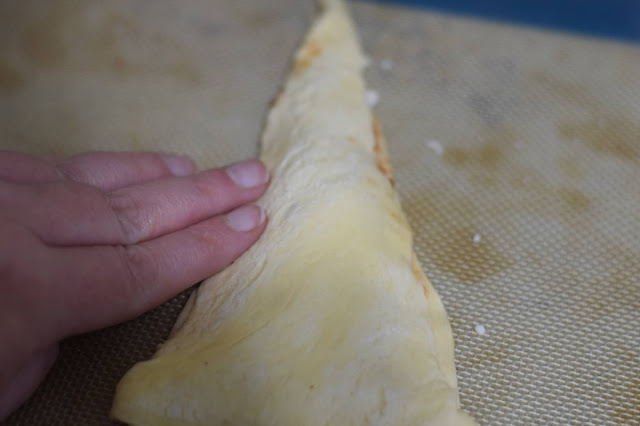 The other crescent roll triangle placed on top of the other and the sides being pressed together.