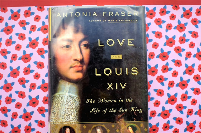 Love and Louis XIV cover against a pink background with red flowers