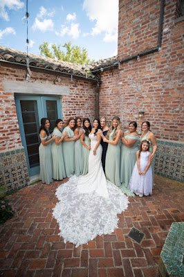 bride with long lace train and bridesmaids in green dresses