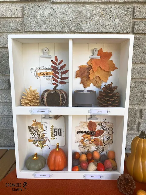 Photo of an upcycled thrifted shadowbox decorated with decor transfers and filled with fall mini decor.