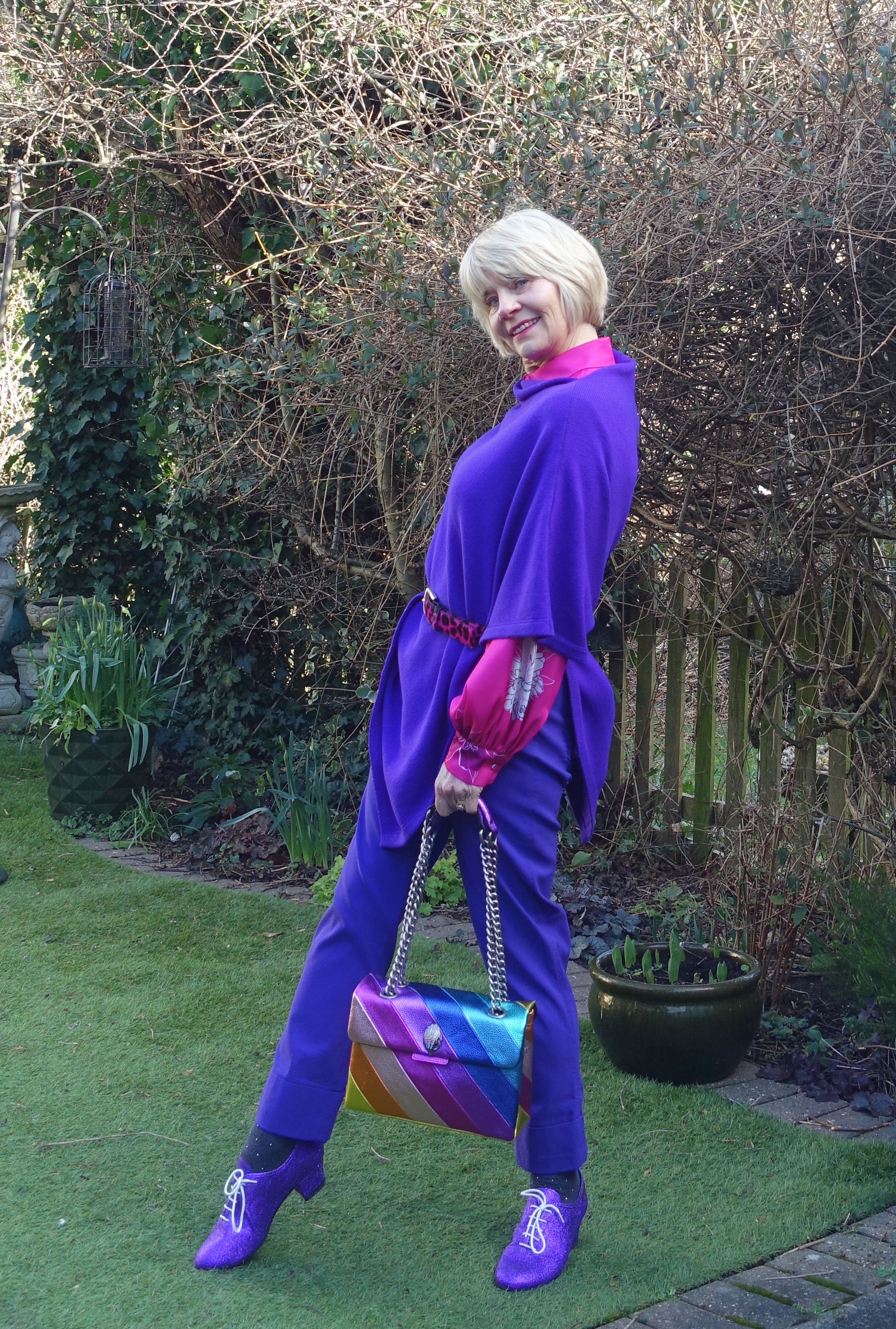 Gail Hanlon from Is This Mutton styles a purple poncho with bright pink, glittery brogues and a rainbow bag