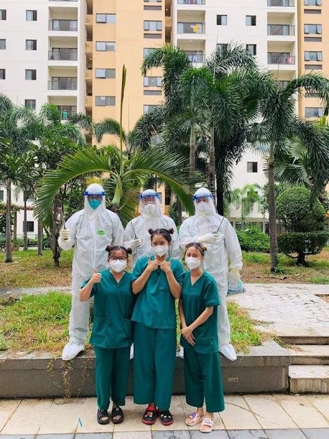 Minh Thư (áo xanh đứng giữa) chụp hình cùng các bác sĩ và tình nguyện viên ở Khoa Lâm sàng 4, Bệnh viện dã chiến số 6. Ảnh: Nhân vật cung cấp