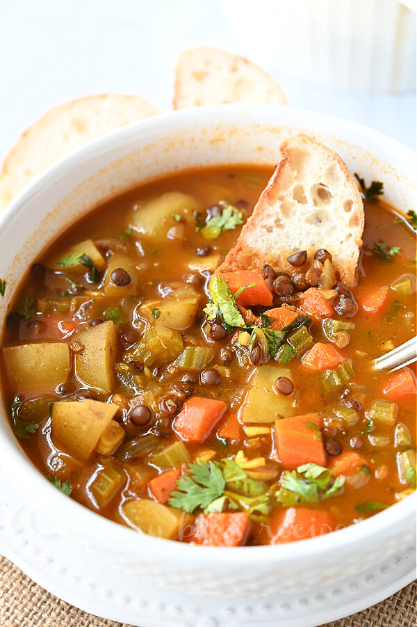 a close up of a white bowl with lentil soup