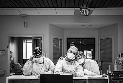 black and white photo from December 2020 of 3 exhausted nurses in masks in the Covid units of St. Vincent's hospital in Santa Fe, NM