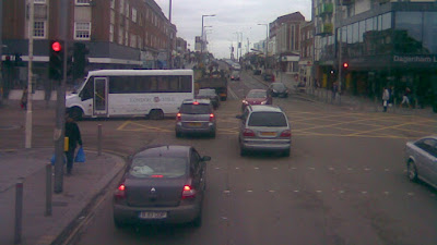 An urban traffic signal controlled junction. There is a yellow box in the road and traffic is gridlocked with people ignoring the traffic signals.