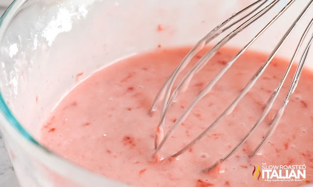 fresh strawberry icing in a bowl with whisk