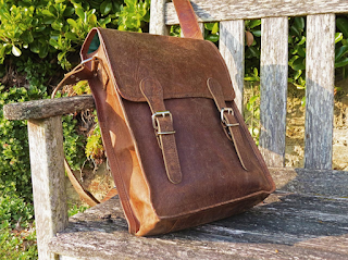 A Light Brown Leather Bag Lying on a Wooden Bench