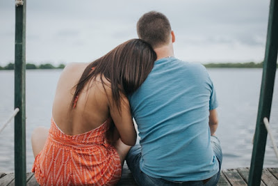 Couple sitting on dock viewing calm sea by Fernanda Nuso via Unsplash - https://unsplash.com/photos/9YWwOWZ7LkI