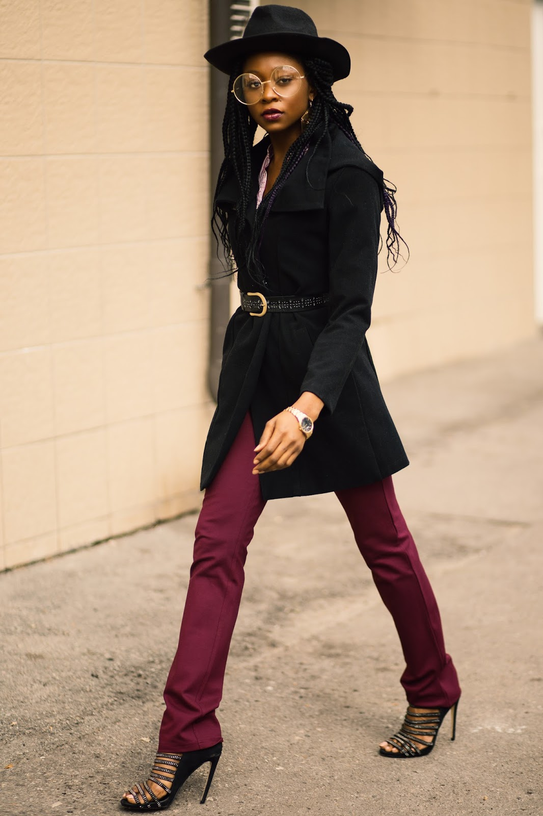 Black hooded coat paired with burgundy flare pants and heels