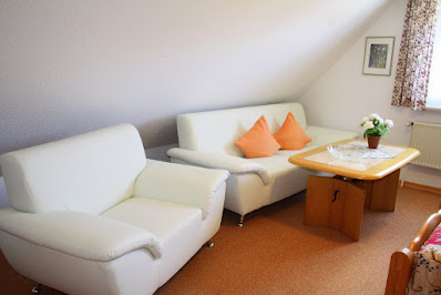 Ferienwohnung Nordseegruß, Ferienwohnung 1 Schlafzimmerfoto mit blick auf Sofas und Sofatisch und Doppelbett