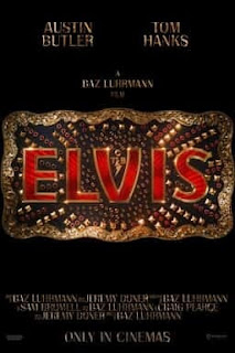 Elvis in red writing on a brass belt buckle