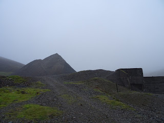 Picture of the grey, rubble path leading up to the grey slag heap at New Glencrieff Mine.  Photograph by Kevin Nosferatu for the Skulferatu Project.
