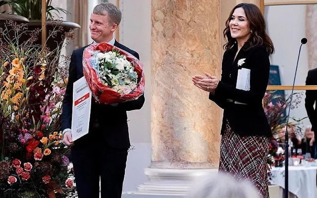 Crown Princess Mary wore a high-waisted boucle tweed midi skirt from Alexander McQueen. Black belted jacket