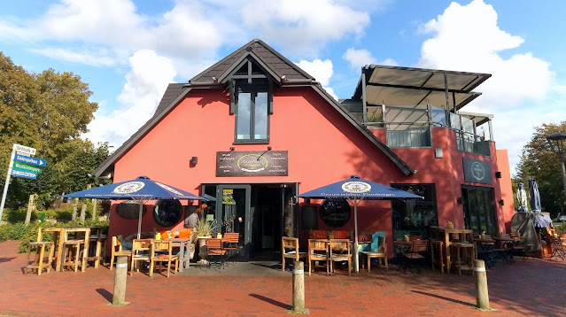 Aussenfoto Fischhaus St. Peter-Ording mit Stühlen, Tischen und Sonnenschirmen