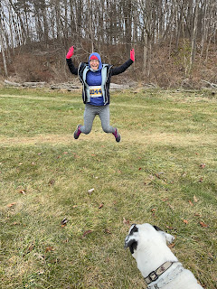 Me in my jacket with my hood up jumping in the air with my mom's dog's head in the photo.