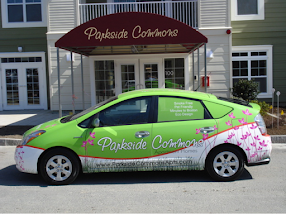 Toyota Prius car wrapped in green, white, and pink with Parkside Commons advertising