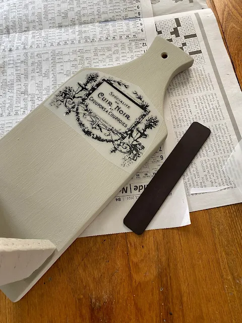 Photo of a decor transfer being applied to the top of a cutting board.