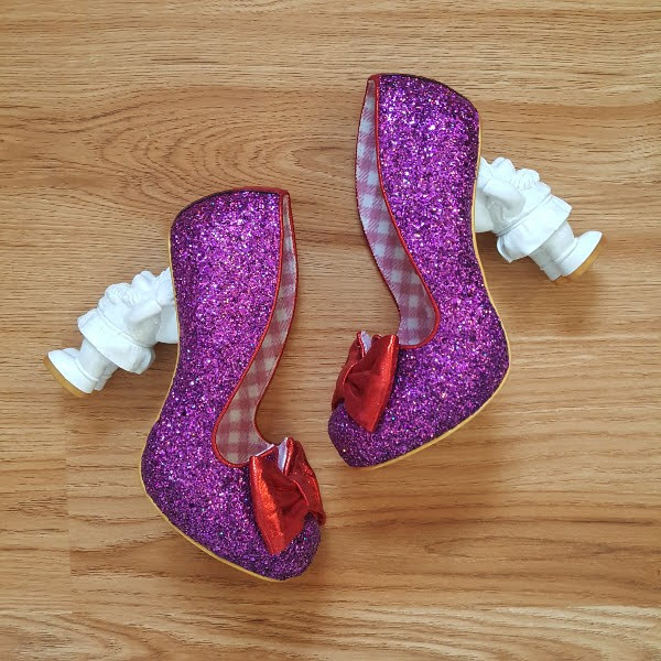 purple glitter shoes on floor with white Santa shaped heels to decorate