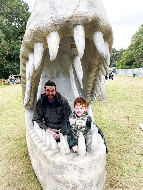 Father and son sitting in a dinosaur mouth