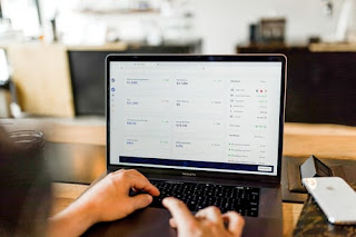 A laptop with two hands pressing the keyboard