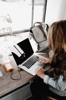 a woman works with an external hard drive connected to laptop