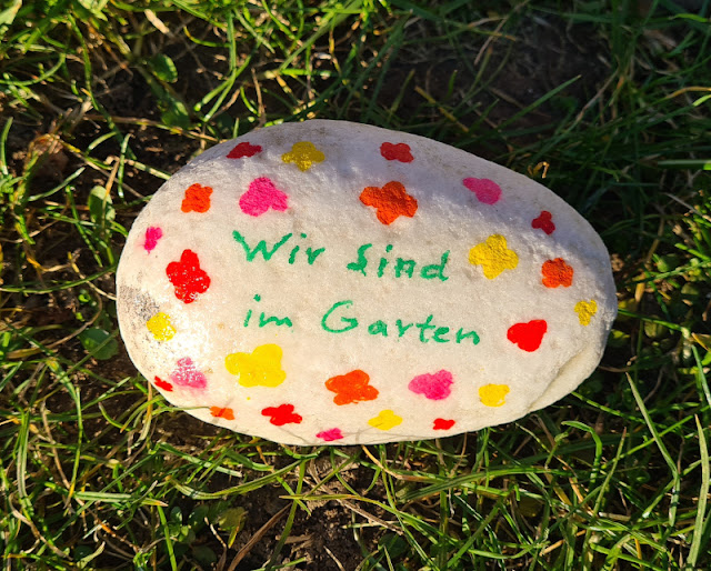 DIY-Anleitung: Steine für den Garten bemalen. "Wir sind im Garten" - dieser Stein fungiert als Nachrichten-Überbringer statt eines Schildes vor der Haustür.